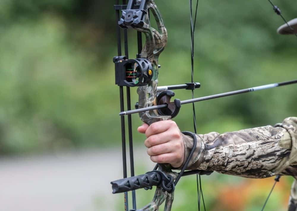 Image of person using compound bow for wild game hunting.
