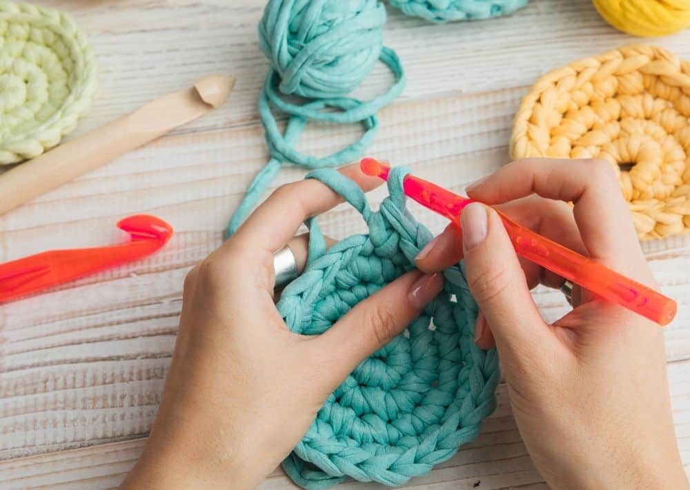 Image of woman crocheting a pot holder.