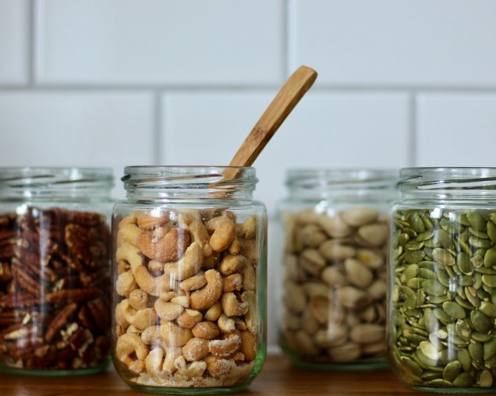 Bulk nuts and seeds stored in glass containers.