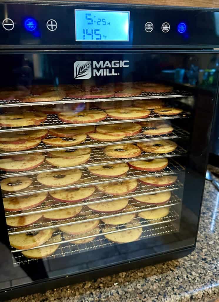 Author's dehydrator with apples drying inside on racks.