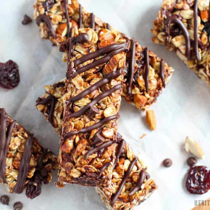 Maple syrup granola bars with cherries and chocolate on a white parchment background.