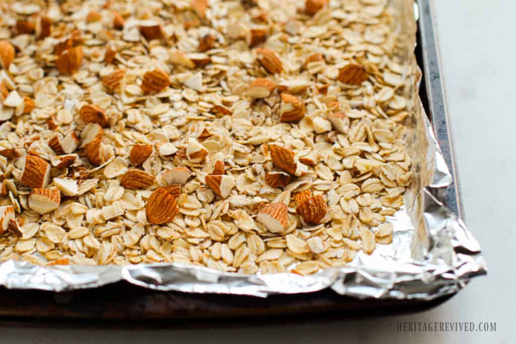 Oats and almonds on a baking sheet.
