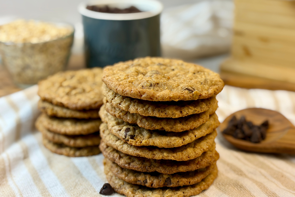 Stack of spelt oatmeal chocolate chip cookies on tea towel.
