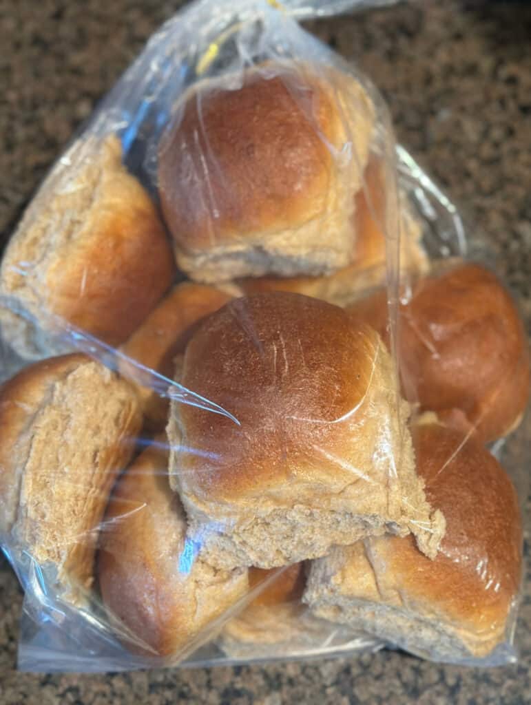 Bag of whole wheat dinner rolls on counter top.
