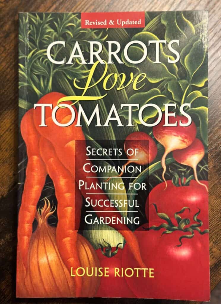 Image of carrots love tomatoes book on wood table.