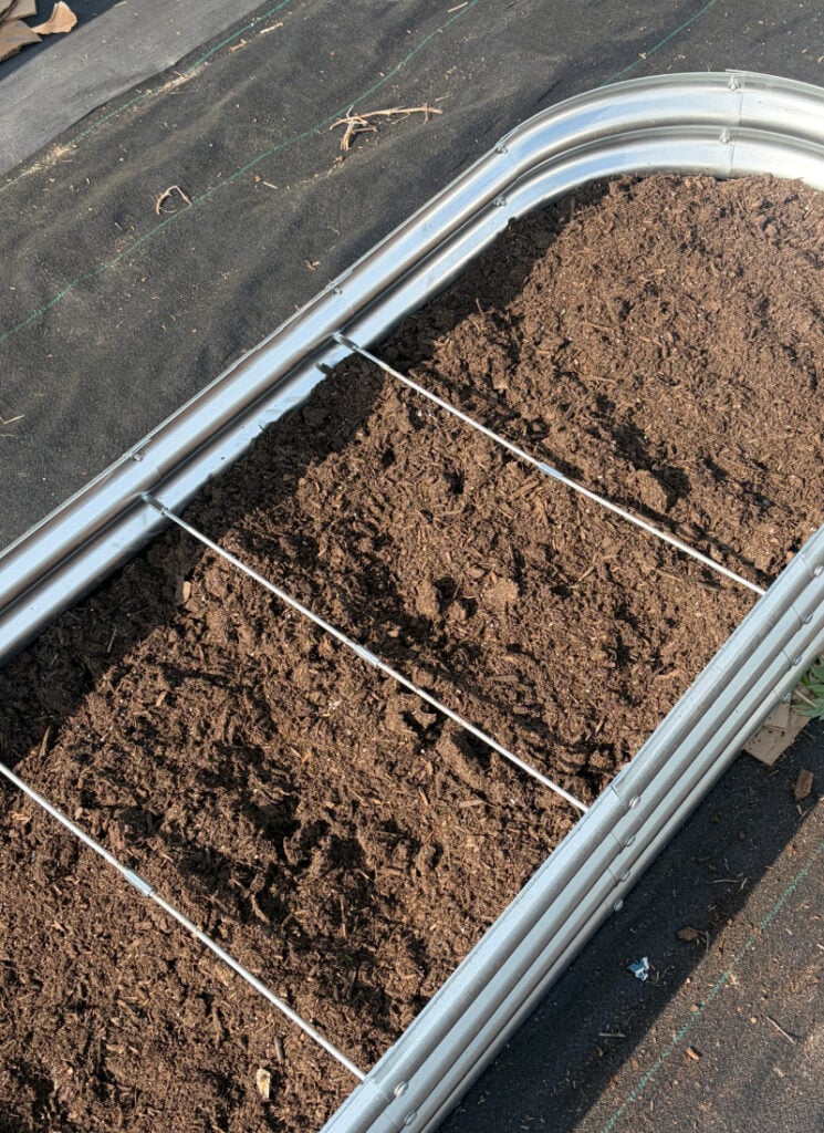 Shallow raised bed with garden soil filled to almost the top.