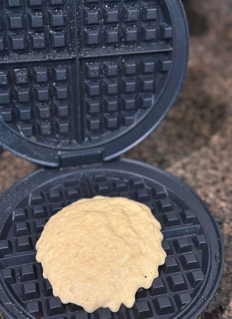 Scooping waffle batter into waffle maker.