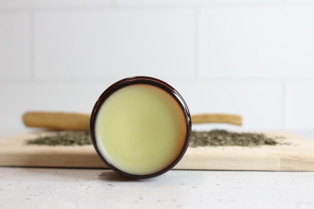 Lemon balm lip balm in amber glass container.