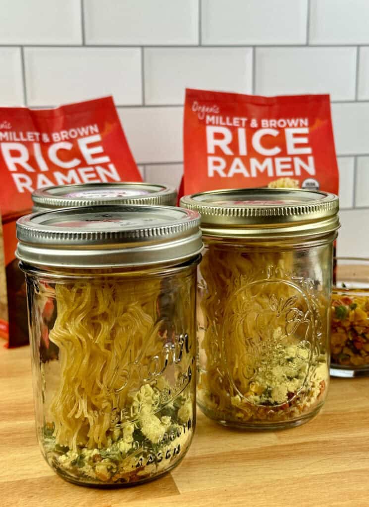 Dry ramen noodles with seasonings in mason jars with lids and rings.