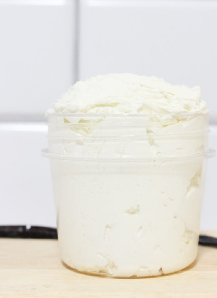 Small glass jar filled with light whipped vanilla body butter mixture.