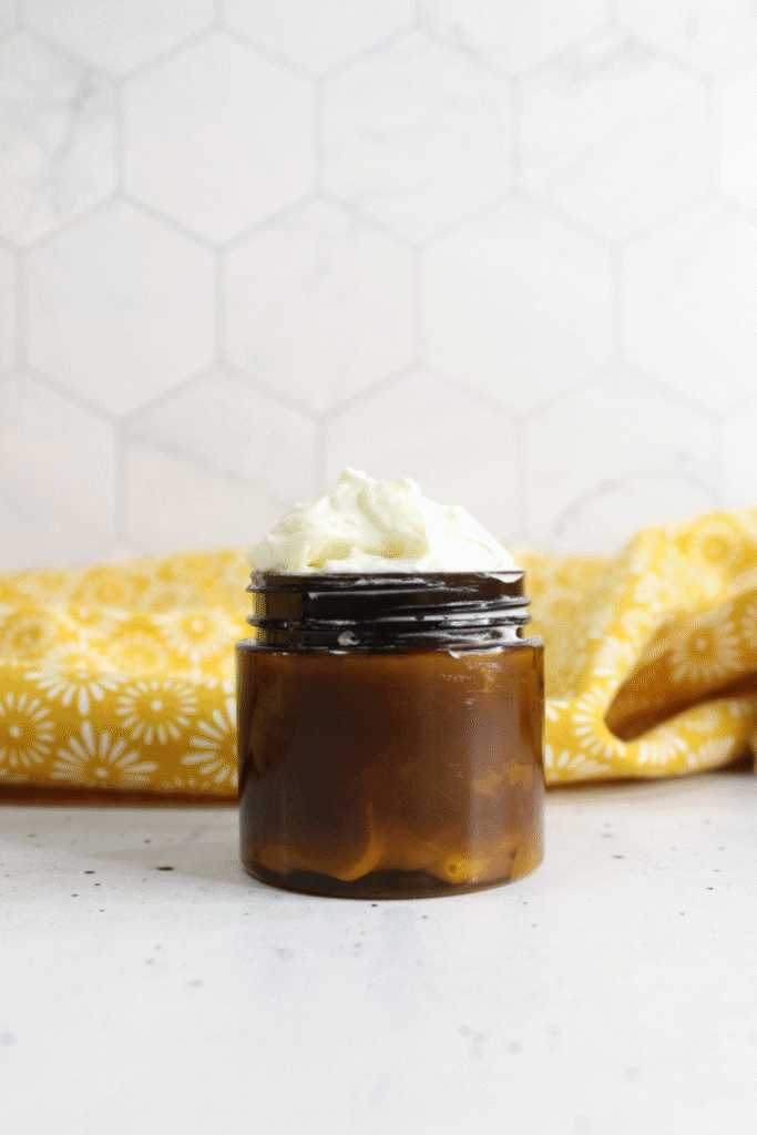 Vertical image of tallow lotion in a jar, whipped above the rim.