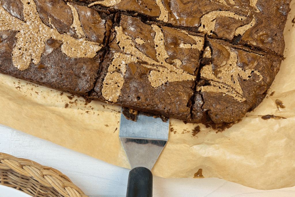 Cutting brownies into squares on parchment paper.