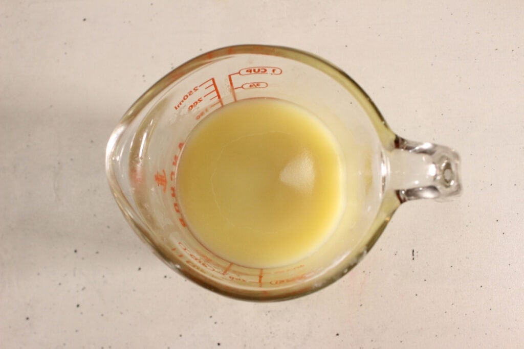 Glass measuring jar with melted oils.