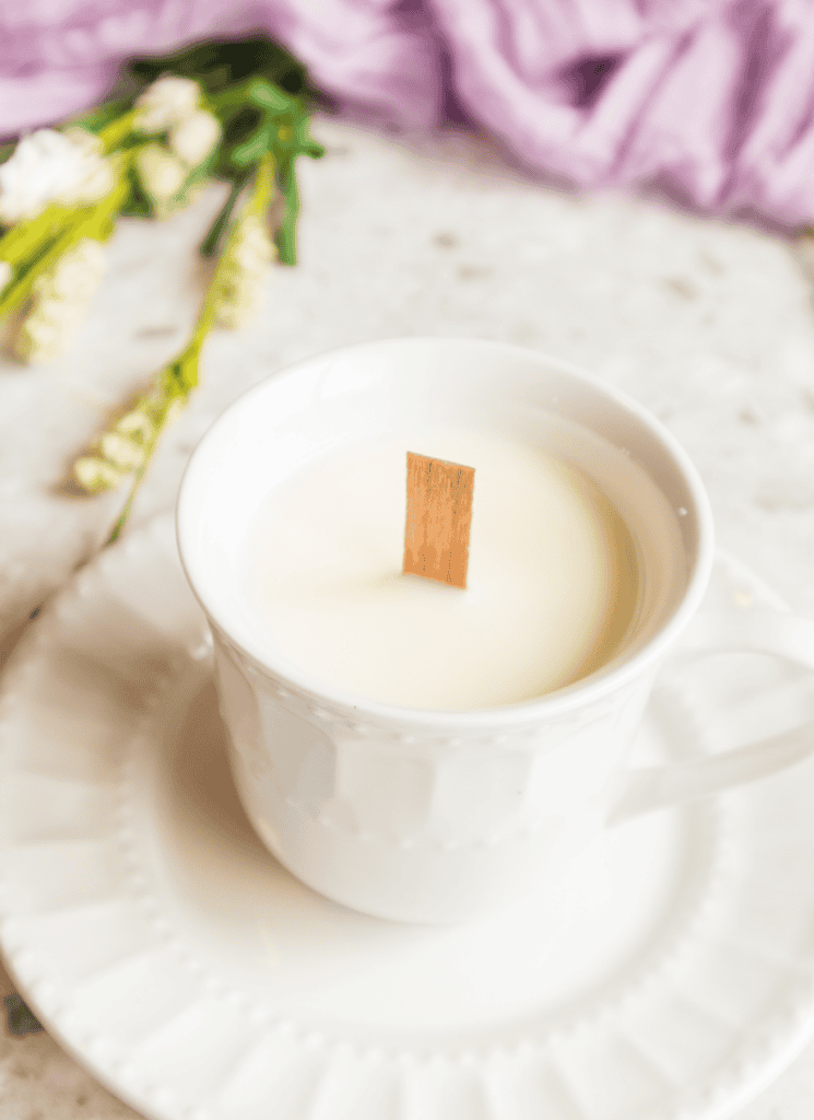vertical image of candle poured into teacup.